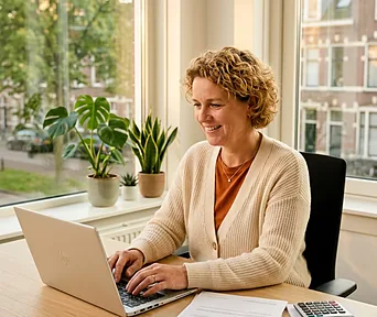 Een medewerker werkt achter haar laptop aan de papieren voor een subsidieaanvraag.